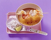 Cold coconut curry soup with skewered prawns