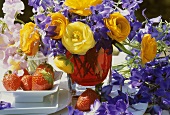 Summer arrangement of ranunculus & delphiniums, strawberries
