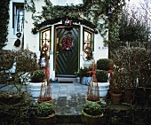 Box trees in front of decorated house door