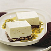 Vanilla squares with biscuit base on passion fruit sauce