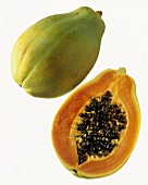 Whole papaya and half a papaya against white background