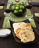 Pita bread with dip on laid table