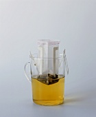 A glass mug of tea with a tea filter