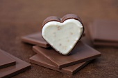 Heart-shaped chocolate pralines on squares of chocolate
