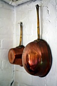 Copper pots hanging on a wall