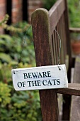 A sign on a garden bench
