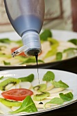 Pear carpaccio being drizzled with balsamic cream