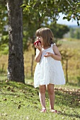 Kleines Mädchen beisst in einen Apfel