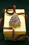 A chocolate Christmas tree on a golden gift box