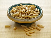Lots of pine nuts in a silver dish and next to it