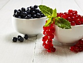 Heidelbeeren und rote Johannisbeeren in Schalen