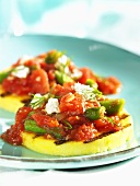 Grilled polenta slices with a tomato and bean sauce and feta cheese