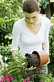 Young woman re-potting plants