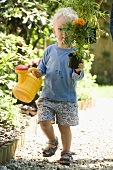 A little boy with a watering can and flowers
