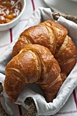 Croissants in a bread basket with marmalade
