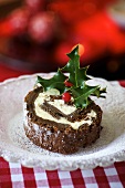 A slice of chocolate yule log with holly