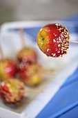 A toffee apple covered with chopped nuts