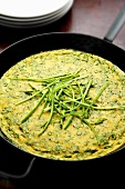 Asparagus-ricotta frittata with chives in a pan