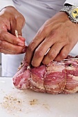 Schweineschulter mit Küchengarn zu einem Rollbraten binden