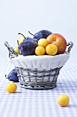 Various types of plums in a basket