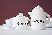 A cream jug and a sugar pot with writing