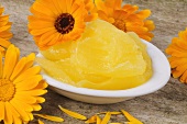 Marigold ointment in small dish with flowers