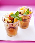 Fruit salad with mint leaves in two glasses