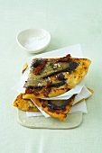 Slices of pizza with dried tomatoes and olives