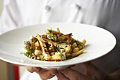 Chef serving poutine (Chips with cheese curds & gravy, Canada)