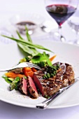 Grilled steak with vegetables, green peppercorns, lemon sauce