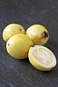 Three whole yellow guavas and half a guava