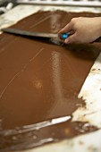 Spreading chocolate on a marble slab