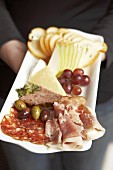 Appetiser platter: cold cuts, cheese, olives, fruit & white bread