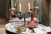 Wine, olives and candles on silver tray on living room table