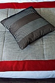 Striped cushion on a bedspread