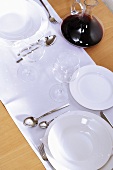 Table laid in white with red wine