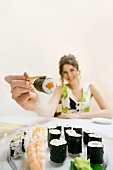 Young woman offering sushi