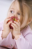 Kleines Mädchen isst einen Apfel