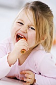 Kleines Mädchen isst eine Karotte
