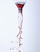 Cherry juice pouring out of a bottle