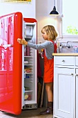 Kleines Mädchen öffnet den Kühlschrank