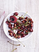 Cherry stones and stalks and half a cherry on plate