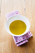 Olive oil in small dish on checked cloth