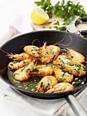 Fried king prawns with garlic and parsley in frying pan