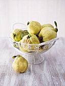 Several quinces in and beside wire basket