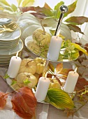 Herbstliche Buffetdeko mit Kürbissen und Kerzen auf Etagere