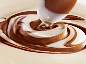 weiße und dunkle Schokoladensauce mit Kochlöffel verrühren