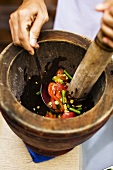 Pounding vegetables in a mortar (Thailand)