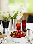 Strawberries in bowl on laid table