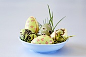 Patterned chocolate Easter eggs in blue dish